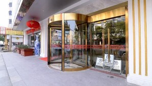 A hotel entrance with a glass revolving door, a red lantern, and a signboard. - Zhouzai Hotel (Yangzhong)