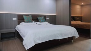 A modern bedroom with a large bed, two nightstands, and a sliding door leading to another room. - Zhouzai Hotel (Yangzhong)