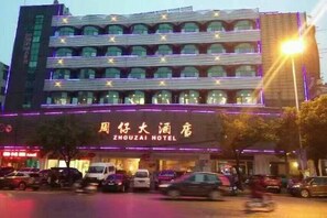 A hotel building with multiple floors and a sign indicating it is the ZHOUZAI HOTEL. - Zhouzai Hotel (Yangzhong)