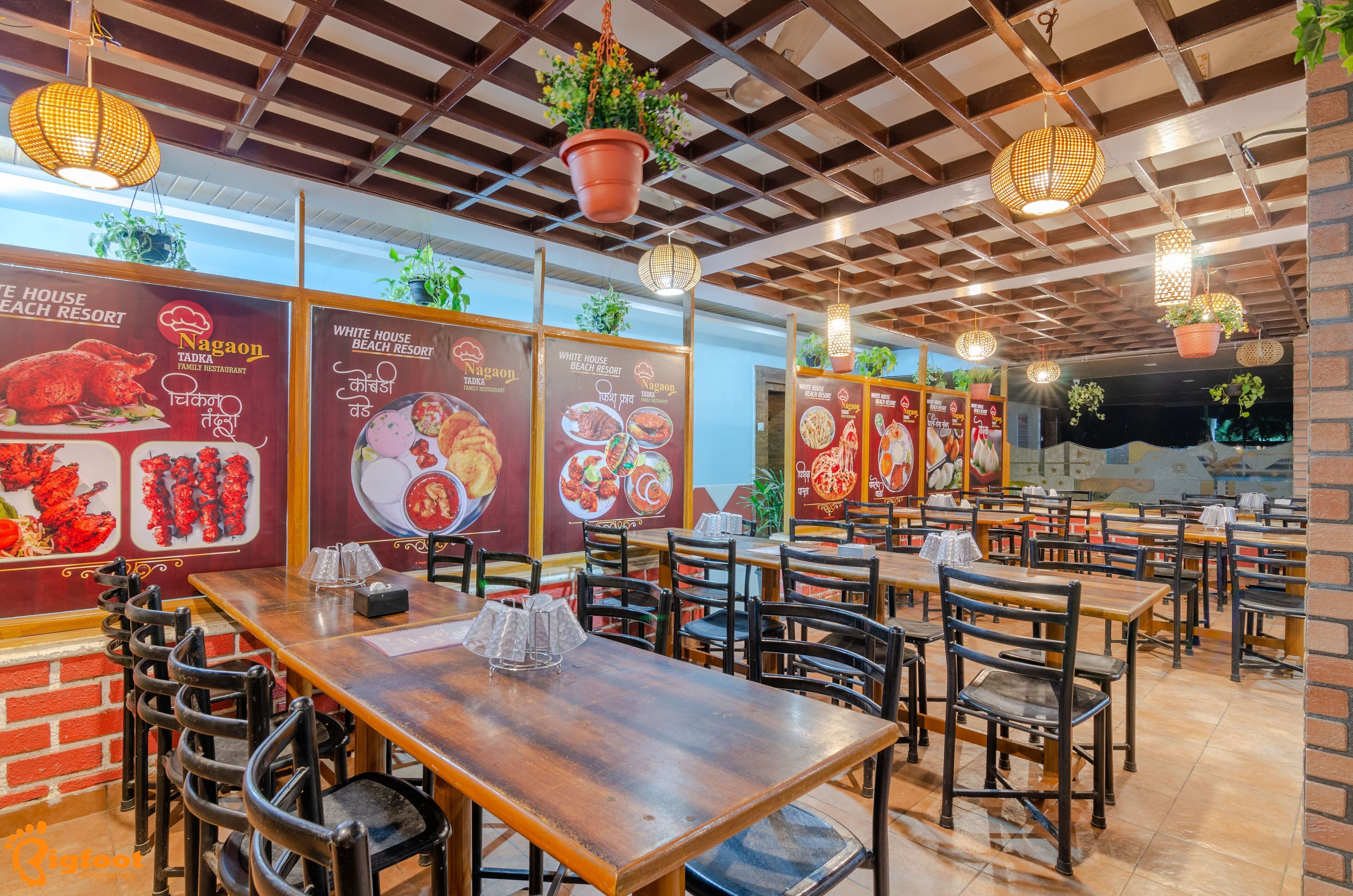 A restaurant with wooden tables and chairs, hanging plants, and menu boards.