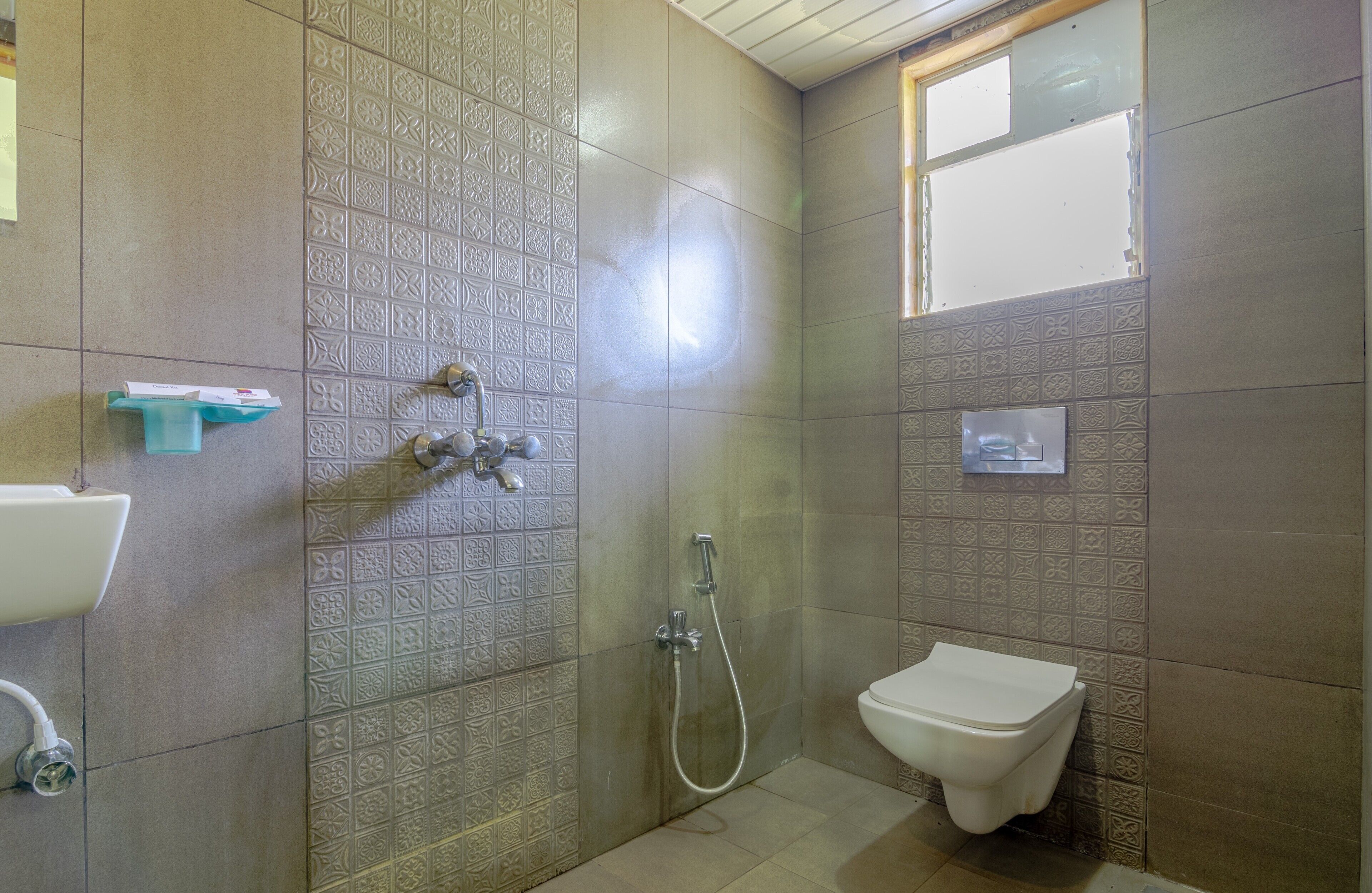 A bathroom with patterned tiles, a shower, a toilet, and a sink.