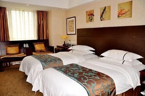 Cozy retreat with a large bed and two additional beds, a window, and wall-mounted artworks.