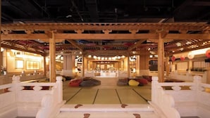 Ein traditionelles japanisches Interieur mit Tatami-Böden, Holzsäulen und einem Sitzbereich mit Tatami-Matten.