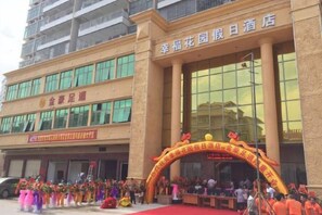 A hotel entrance with a red carpet, a large archway with Chinese characters, and a crowd of people. - HAPPINESS HOLIDAYINNL (Jiexi)