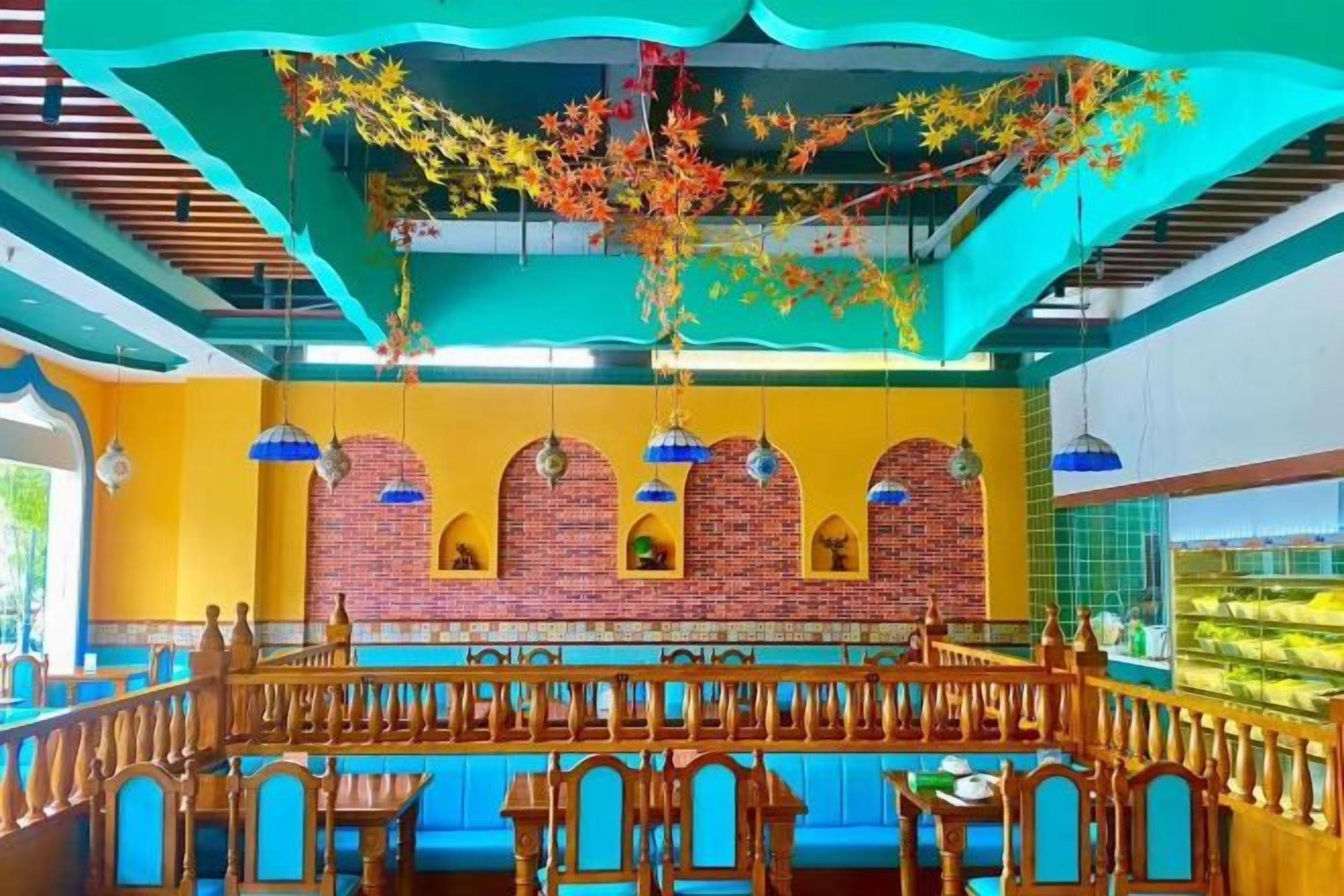 Un restaurante con pared de ladrillo, faroles colgantes y un balcón con vistas.