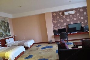 A hotel room with two beds, a desk with a computer, a television, and a carpeted floor. - Qujing Youth Network Hotel (Qujing)