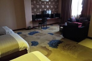 A hotel room with two beds, a desk with a computer, a chair, and a sofa. - Qujing Youth Network Hotel (Qujing)