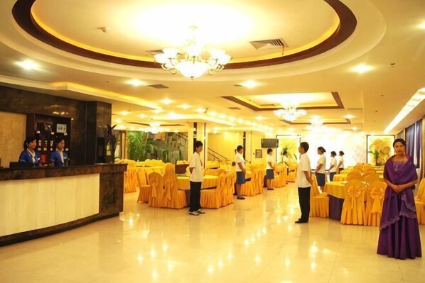 A hotel lobby with a reception desk, a staircase, and tables set up for a function. - Wanshui Qianshan Hotel (Xiuwu)
