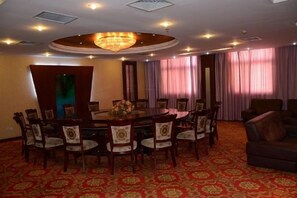 A conference room with a round table, chairs, and a chandelier. - Wanshui Qianshan Hotel (Xiuwu)