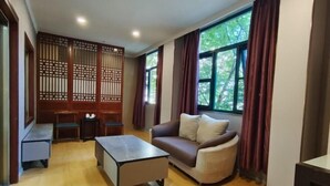 Uma sala de estar com sofá, mesa de centro e um divisório de madeira.