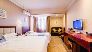 A hotel room with two beds, a desk, a television, and a view of the hallway.