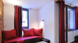 A room with a bed, a table, and a window.