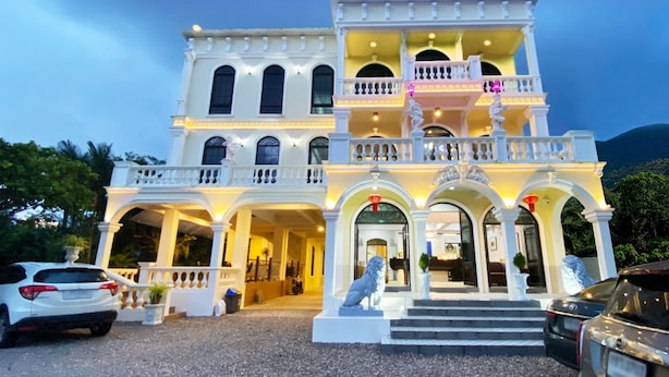 A large, multi-story building with a grand entrance, featuring a statue, steps, and a balcony. - Daddy Dream Hotel and Residence (Ranong)