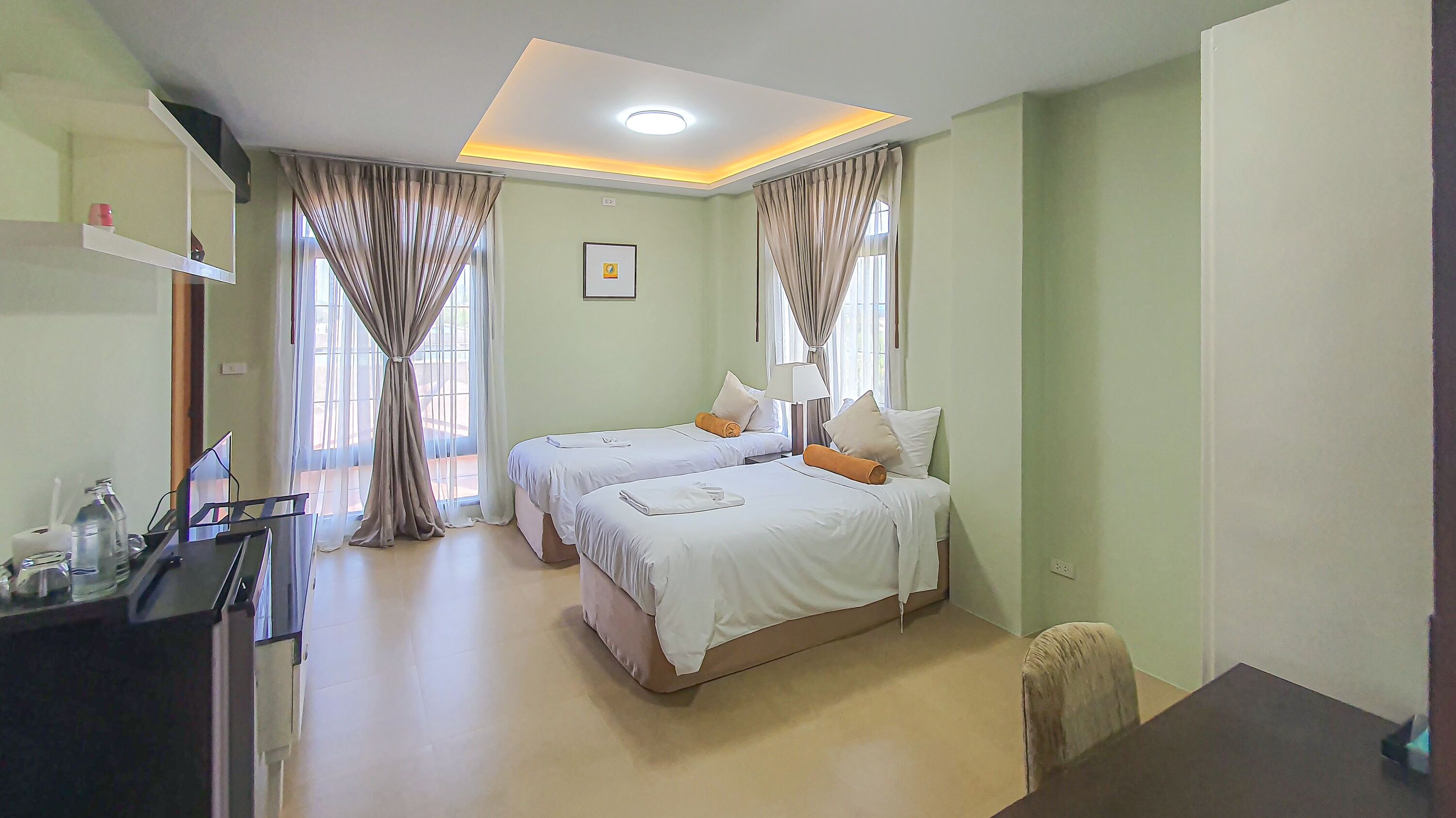A hotel room with two beds, a desk, and a chair.
