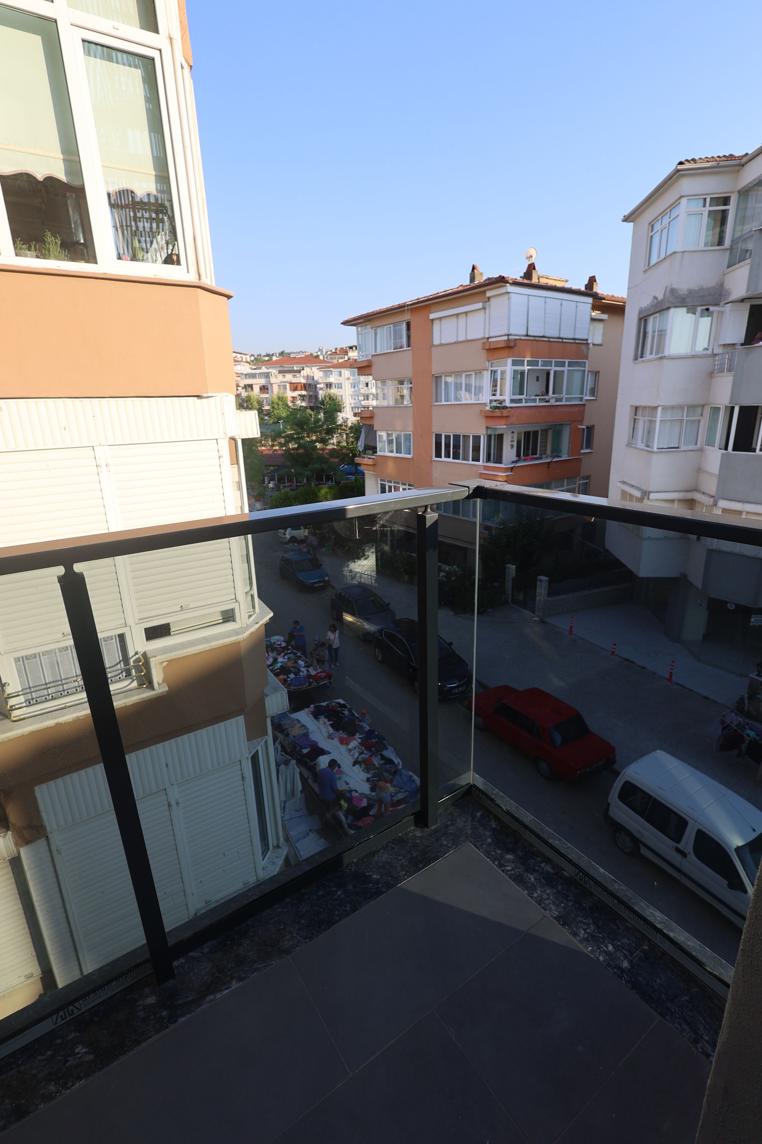 A residential building with multiple floors, balconies, and a street view.