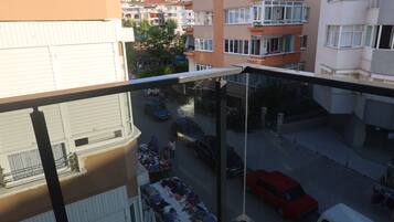 A residential building with multiple floors, balconies, and a street view.