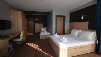 Una habitación de hotel moderna con una cama grande, un escritorio y una televisión.