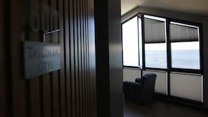 Habitación de hotel con un ventanal que ofrece vista al mar.