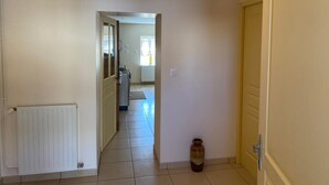 A hallway with a radiator, a door, and a vase on the floor. - Peaceful farmhouse with valley view and terrace (Mazirat)