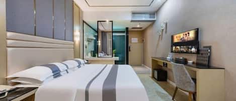A hotel room with a bed, a desk, a chair, a television, and a mirror.