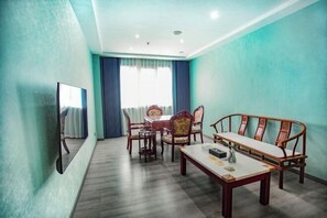 A room with a wooden dining table, chairs, a sofa, a TV, and a large window with curtains. - A Fu Er Lian Suo Jiu Dian (Youyang County)