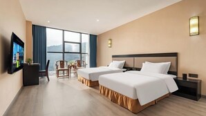 Een hotelkamer met twee bedden, een televisie, een bureau en een stoel.