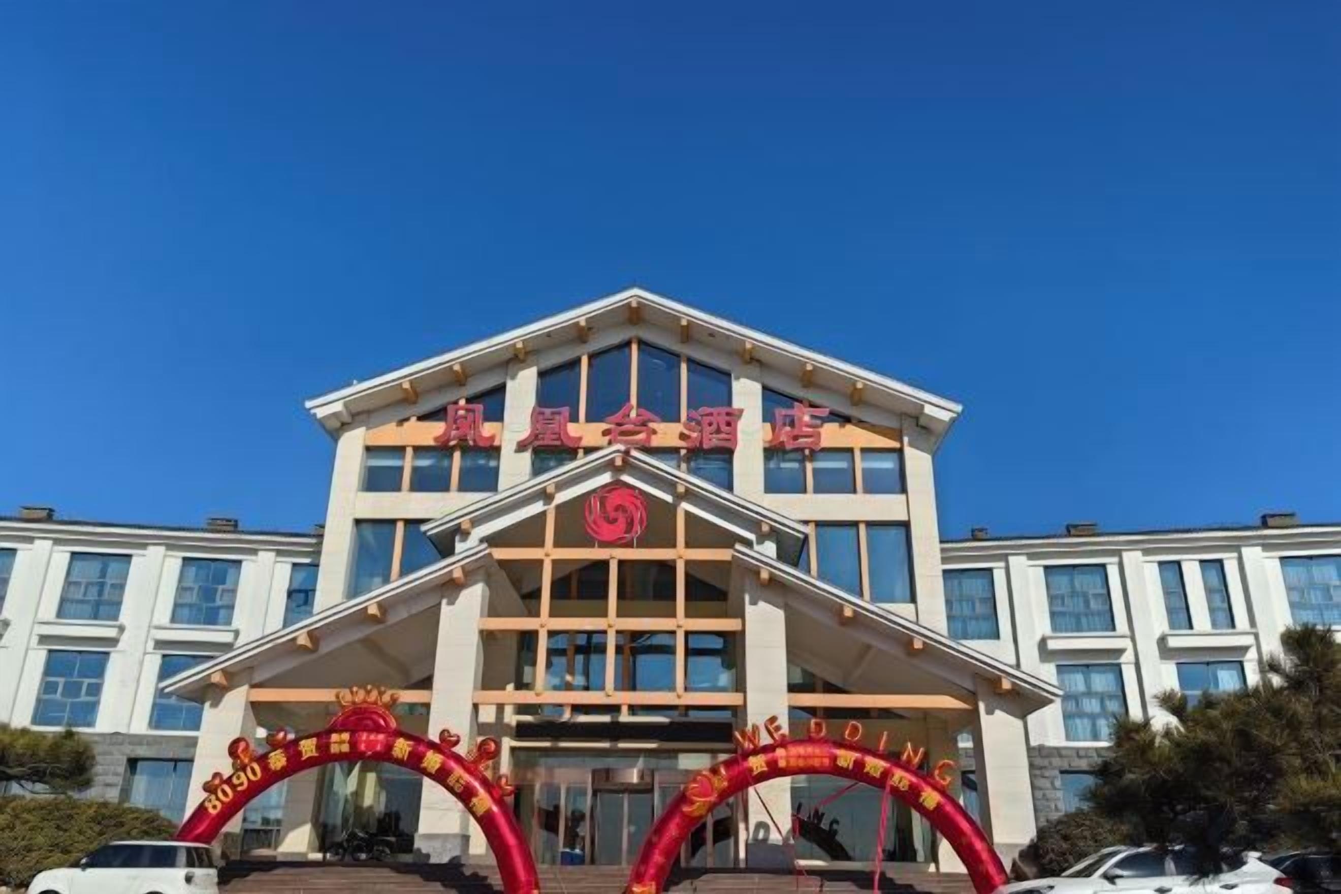 Un edificio de varios pisos con una entrada destacada que presenta un arco rojo con caracteres chinos.