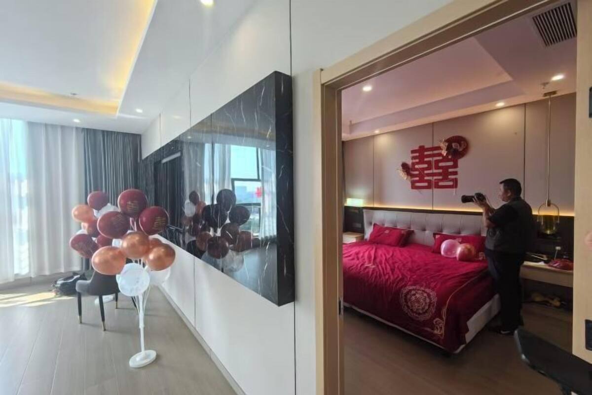 Une chambre d’hôtel moderne avec un grand lit, un téléviseur fixé au mur et un balcon avec vue.