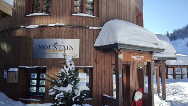 Un edificio de madera con un cartel que dice "MOUNTAIN collection LA PLAGNE".