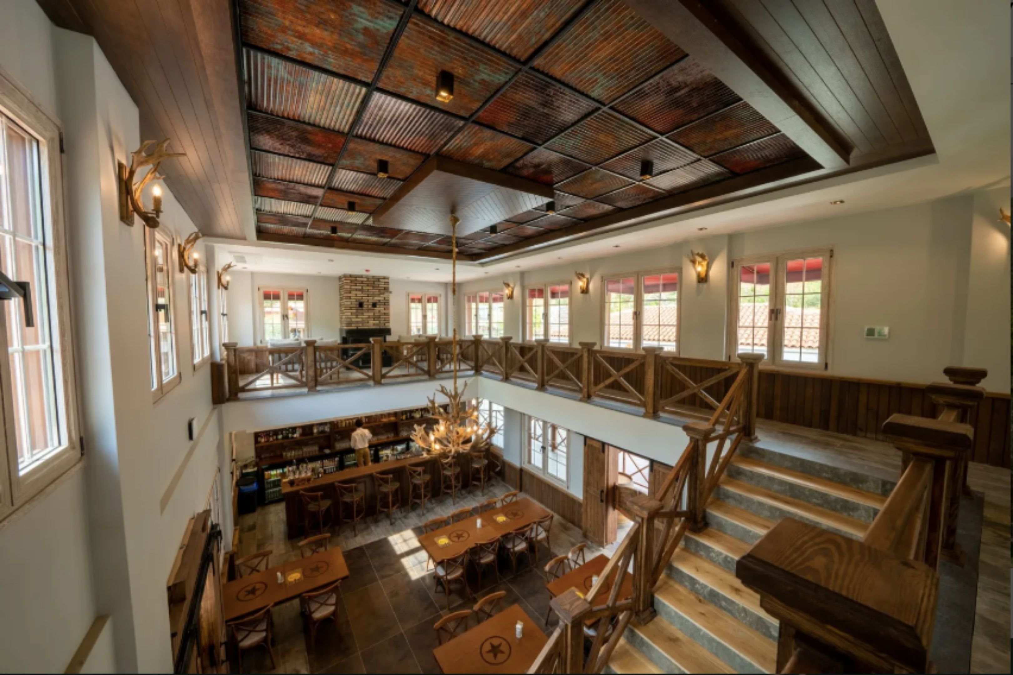 A spacious interior with a high ceiling, wooden beams, and a mezzanine level.