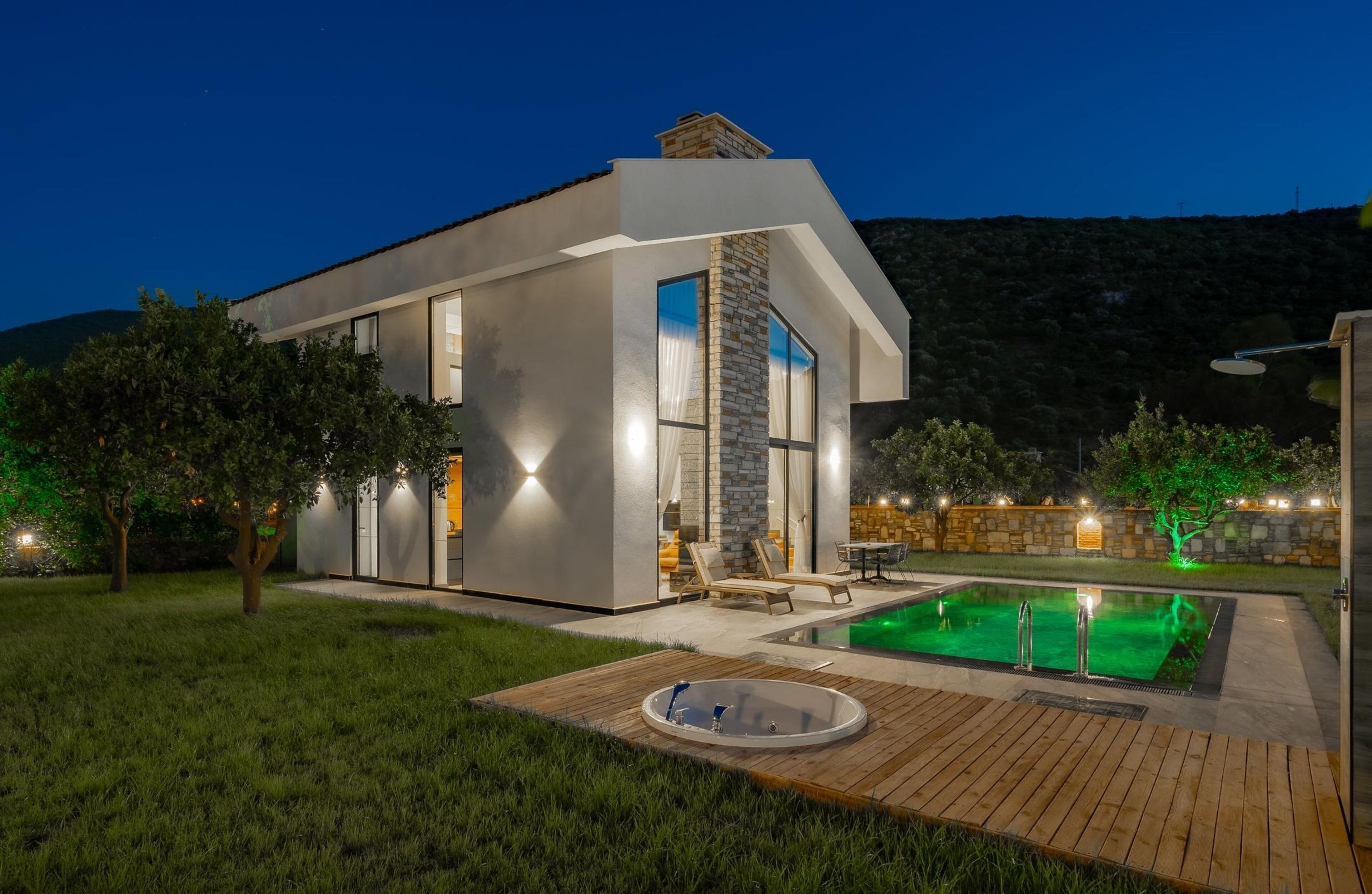 A modern house with a swimming pool, a hot tub, and a patio area.