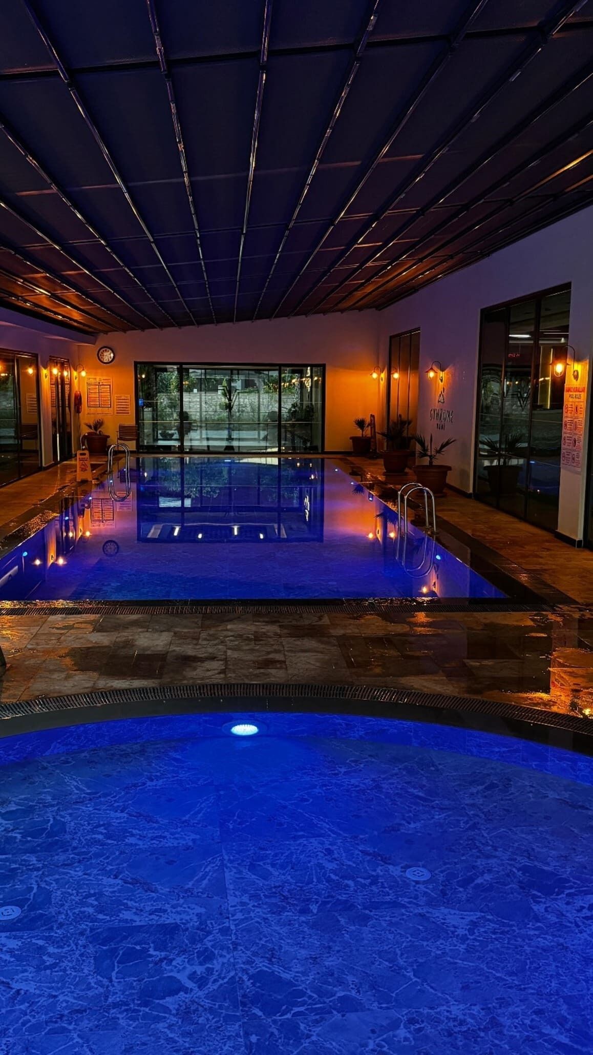 Een binnenzwembad, een buitenzwembad, parasols voor strand/zwembad