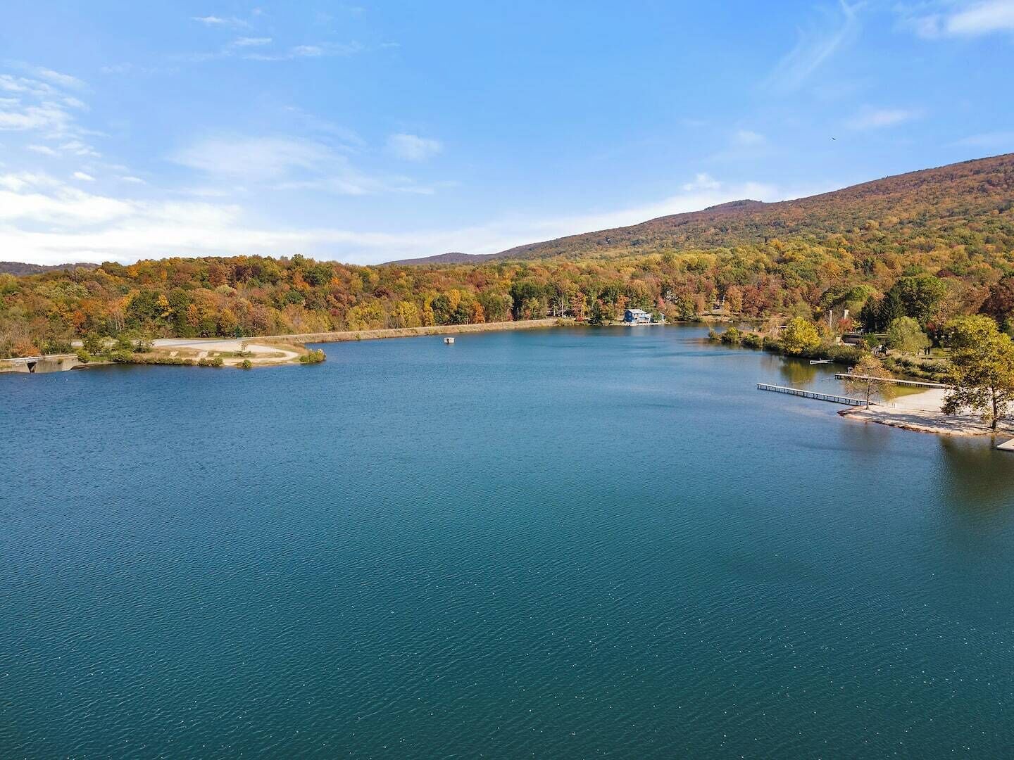 A large lake surrounded by forested hills.