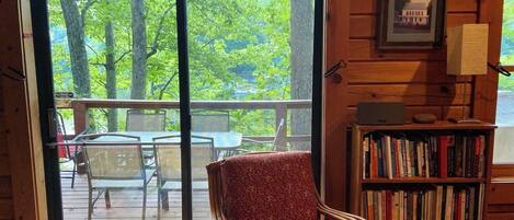 A wooden cabin interior with a sliding glass door leading to an outdoor deck.