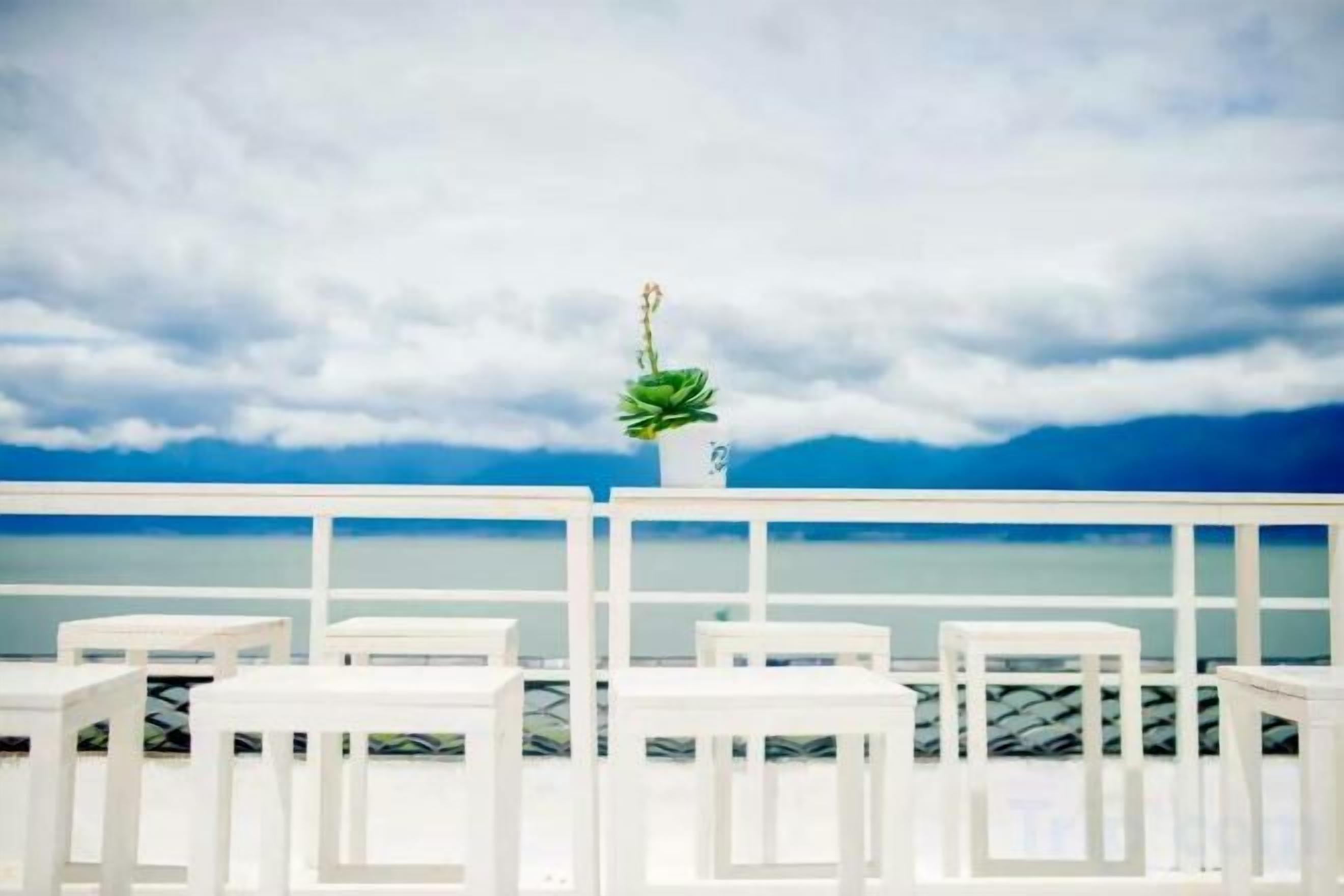 Un balcón blanco con vistas al mar y un cielo nublado.