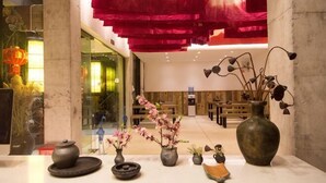 Un área de recepción con un jarrón grande, varios jarrones más pequeños y un juego de té tradicional.