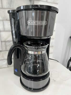 A BLACK+DECKER coffee maker with a clear glass carafe and a digital display.