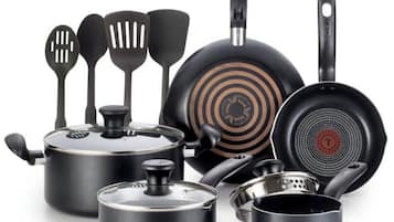 Een verzameling zwarte keukenaccessoires en kookgerei, waaronder een koekenpan, spatels en pannen.