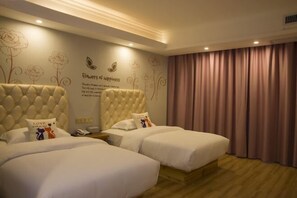 A hotel room with two beds, a wall with floral and butterfly decorations, and a large window with curtains. - Tao Flute Hotel (Guilin)