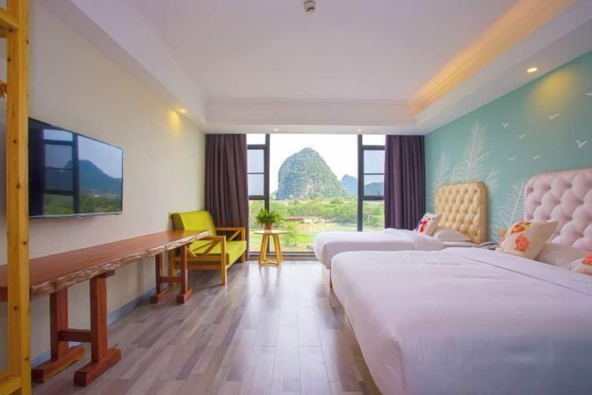 Habitación de hotel con una cama grande, un escritorio, una silla y un televisor.