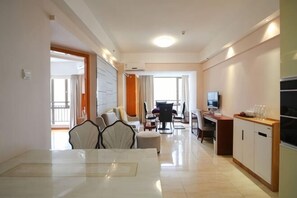 A hotel room with a dining area, a TV, and a kitchenette. - roomme hospitality (Foshan)