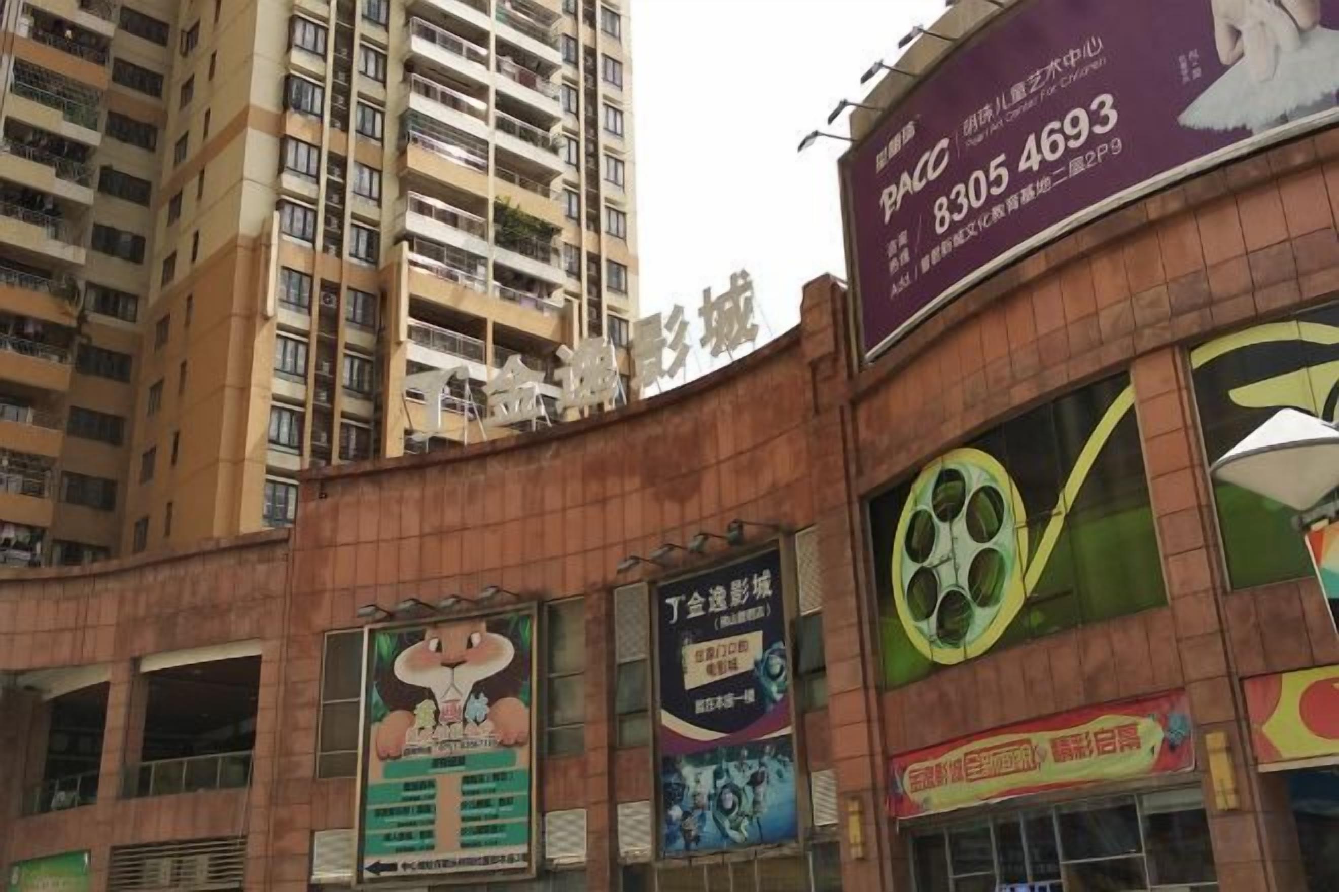 A multi-story building with a large billboard advertising a cinema.