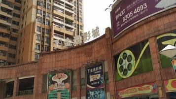 A multi-story building with a large billboard advertising a cinema.