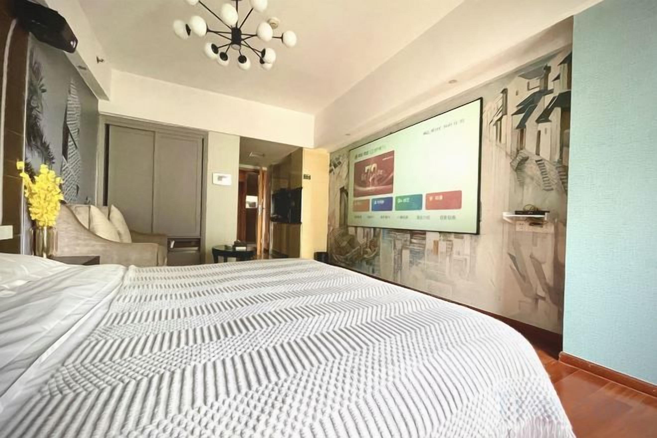 Ett hotellrum med en stor säng, en tv och ett konstverk som hänger på väggen.