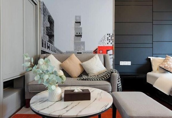 A modern living room with a sofa, a round coffee table, and a decorative vase.