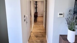 A hallway with wooden flooring, white walls, and a white door at the end. - La Terrasse in the heart of the old town. (Aix-en-Provence)