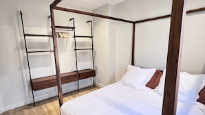 A bedroom with a four-poster bed, wooden flooring, and a built-in shelving unit. - La Terrasse in the heart of the old town. (Aix-en-Provence)