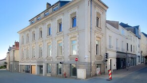 A multi-story building with large windows and a no entry sign. - Corner Set (Cholet)
