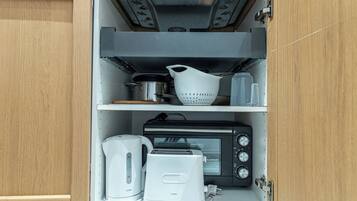 Una cocina con tostadora, hervidor y horno tostador negro en la encimera.