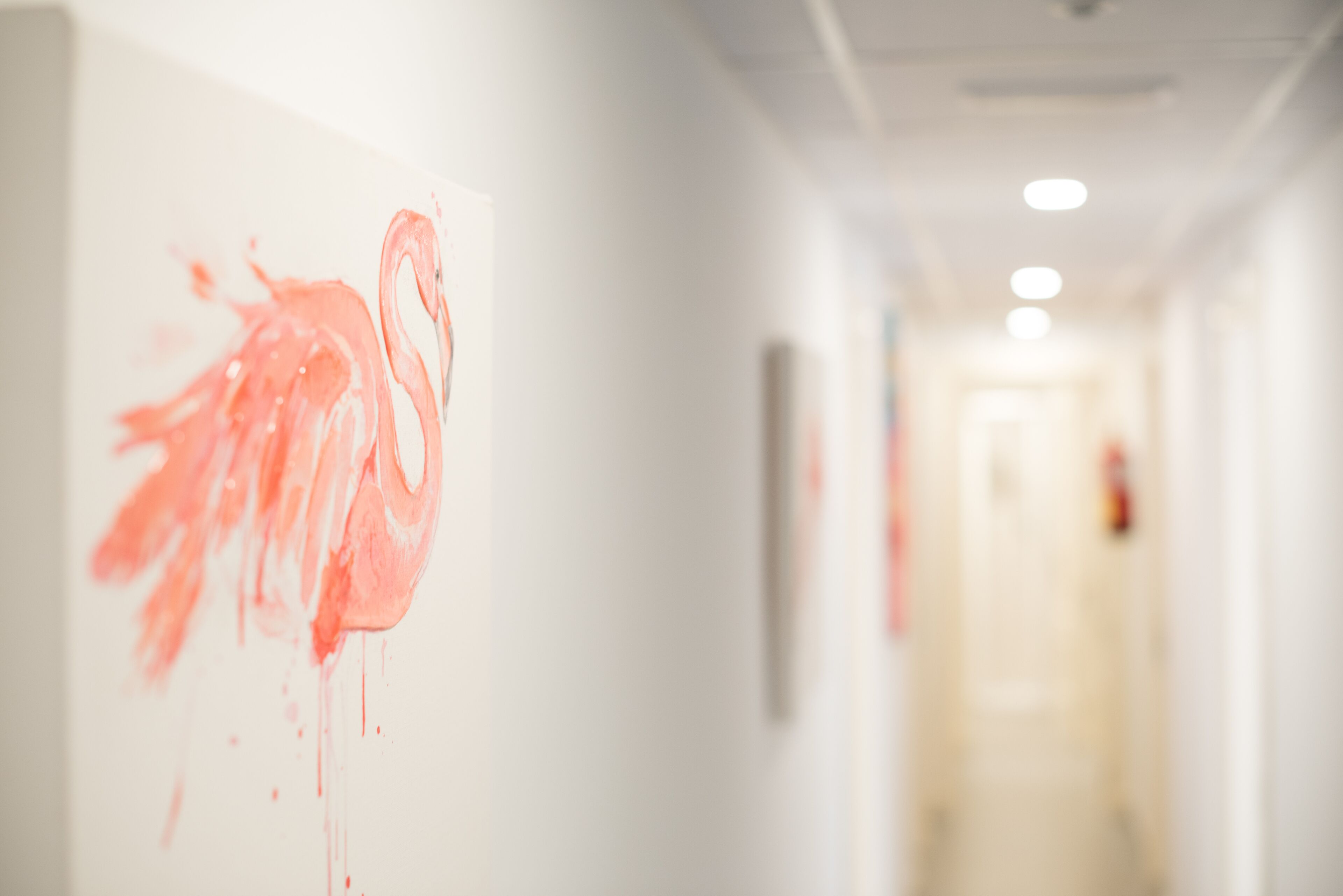 A hallway with a pink flamingo artwork on the wall.